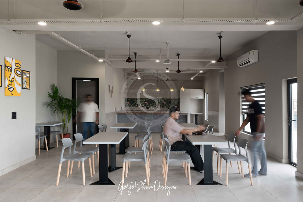 Modern cafe and breakout zone featuring sleek tables, minimalist chairs, and artistic decor, creating a relaxed atmosphere for socializing or unwinding.