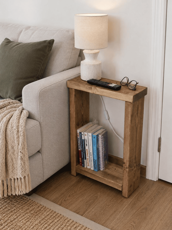 Skinny side table beside grey fabric sofa