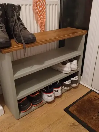 Grey wooden shoe rack with boots and various shoes