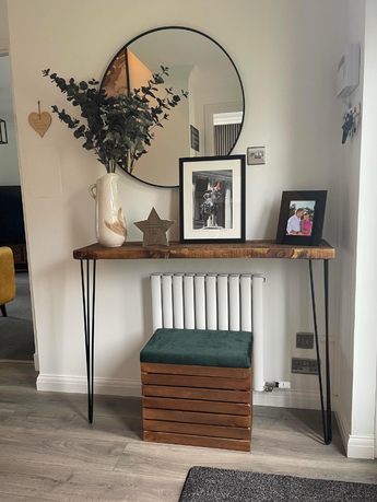 Console table with mirror, decor, and green storage ottoman