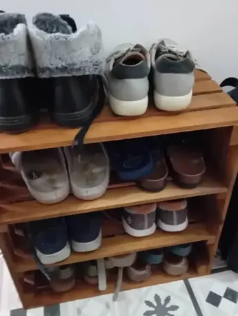 Three-tier wooden shoe rack with shoes