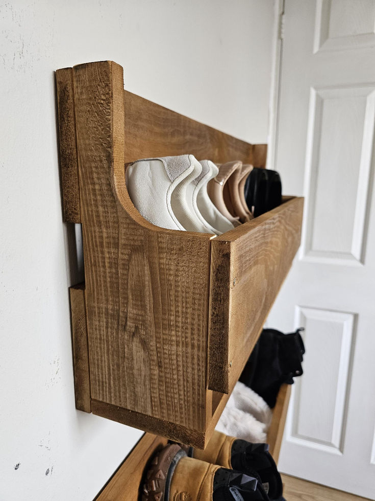 Floating solid wood shoe rack mounted on a hallway wall.
