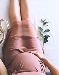 Pregnant woman in dress with ultrasound image. Mother with wicker basket of cute tiny stuf