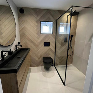 Modern bathroom installation featuring a walk in shower and black finished fittings