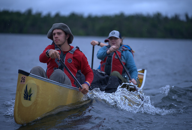 A paddler drives a yellow canoe through the water at Northern Tier.