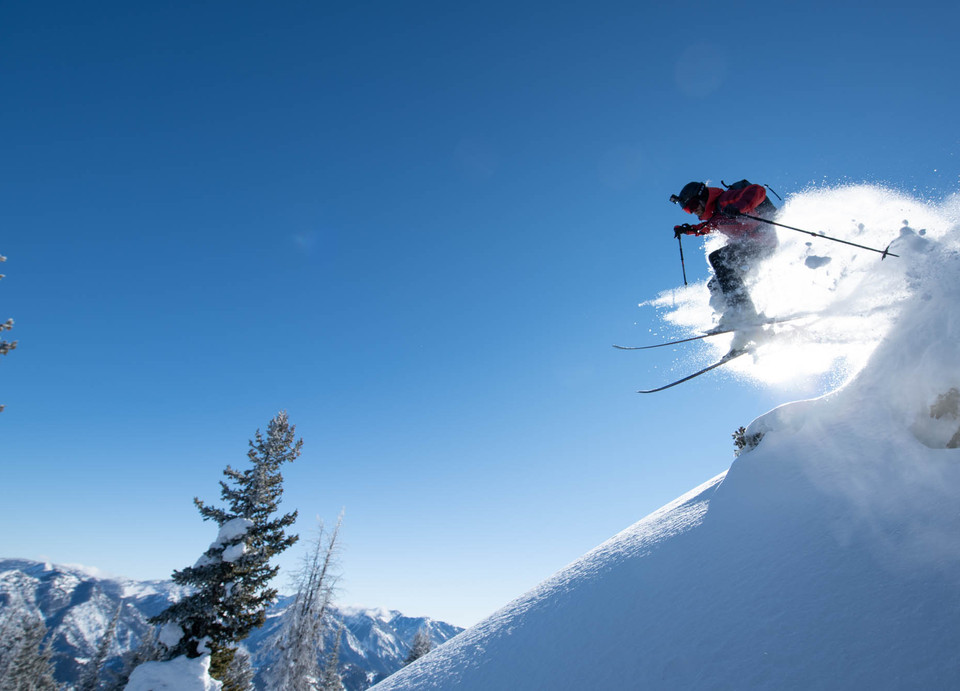A skier descending an open snowy slope