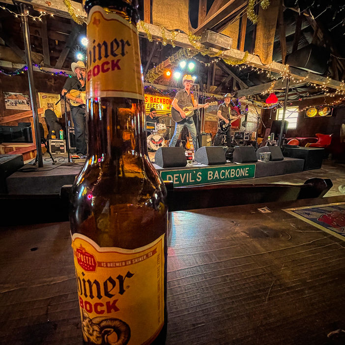 a giant beer bottle makes a band on stage look tiny