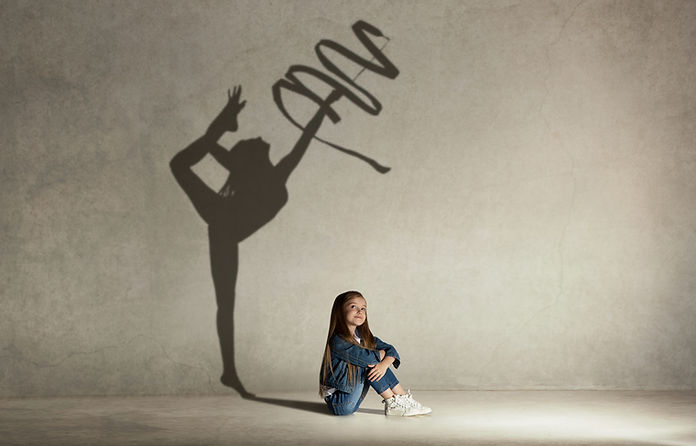 Baby girl dreaming about gymnast profession. Childhood and dream concept. Conceptual image