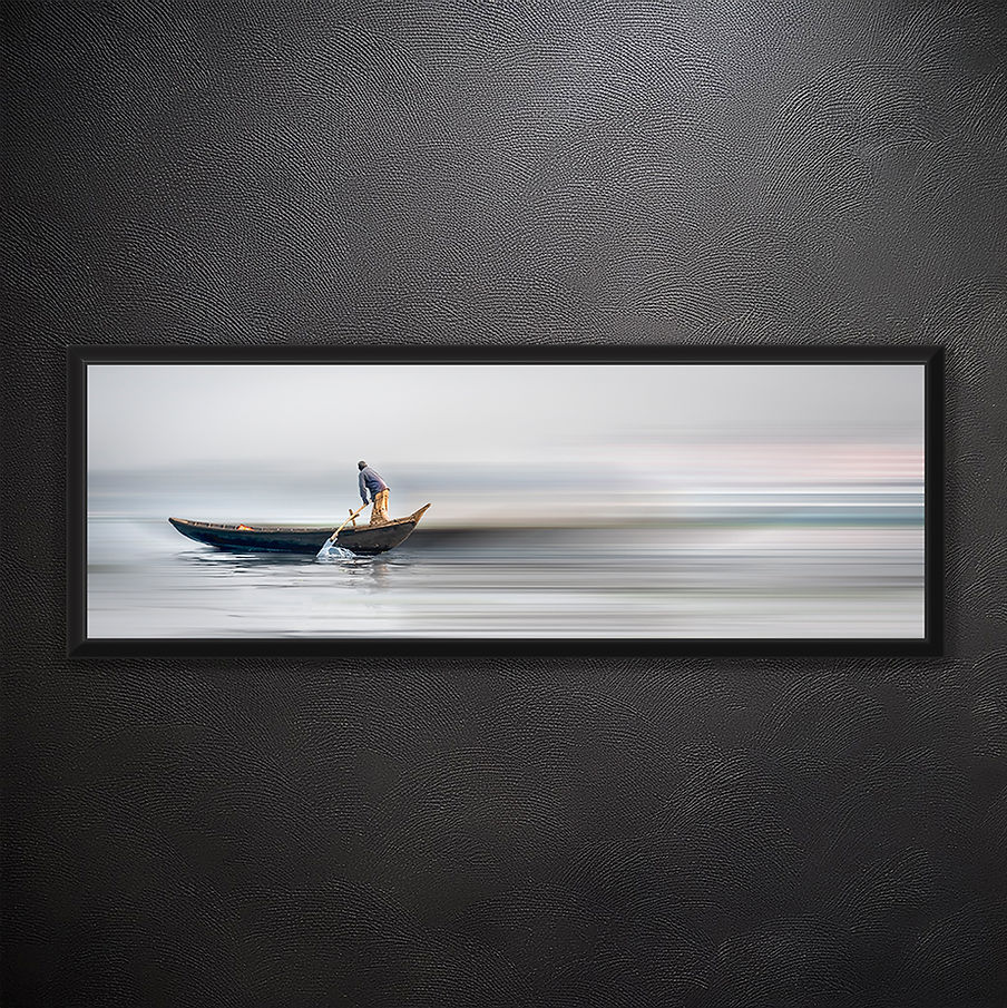 Pirogue de Dhaka
Numéro de référence de l'œuvre
19A_3424
Lieu et date de prise
Dhaka, Bangladesh, 2020
Description
Seul sur les eaux immobiles, l'homme rame dans un silence presque sacré. Sa pirogue glisse sur la surface comme une plume portée par le souffle du matin. Le mouvement répété de ses bras devient une méditation, une danse lente avec le fleuve. Loin du tumulte urbain, il trouve dans ces gestes une harmonie profonde, reliant le ciel voilé et la rivière infinie.