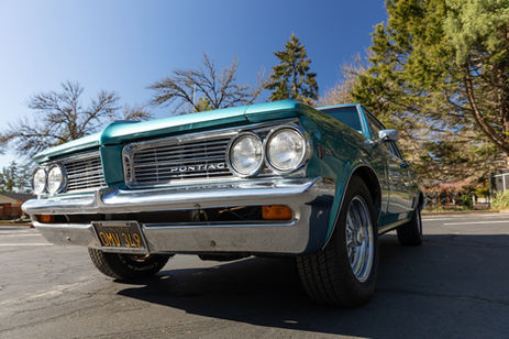 Low-angle shot of a 1964 Pontiac Le Mans highlighting its aggressive stance and front-end design