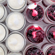 small glass containers with yoghurt ice cream and berries