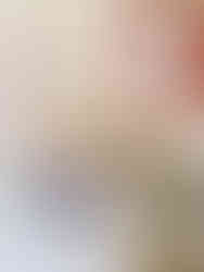 A cafe wall with quirky art: A white T-shirt with "AntiSocial" text, a framed sign reading "Call Me AntiSocial But Don’t Call Me," wine bottles, and colorful packages.