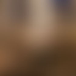 Elegant restaurant with neatly set tables and empty glasses. Framed black-and-white photos on walls. Warm lighting creates a cozy ambiance.