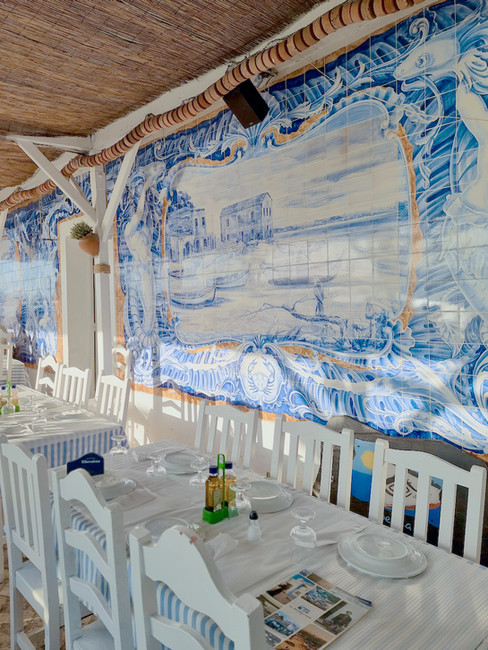 A fish restaurant with blue and white tiles and white chairs