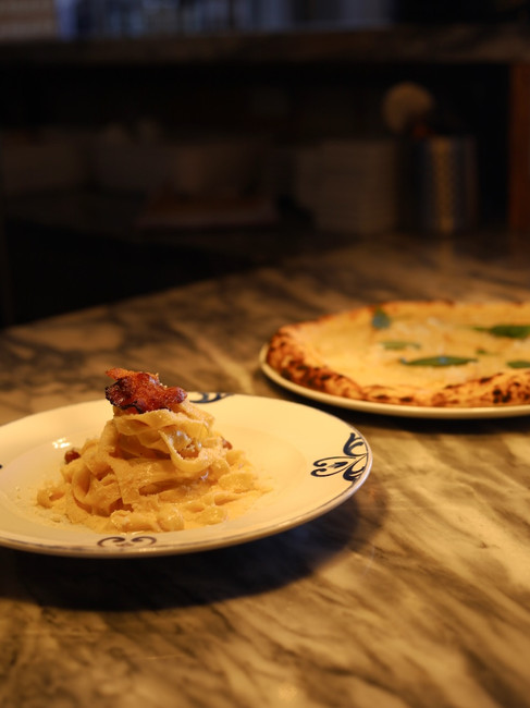One dish of pasta and one dish of pizza