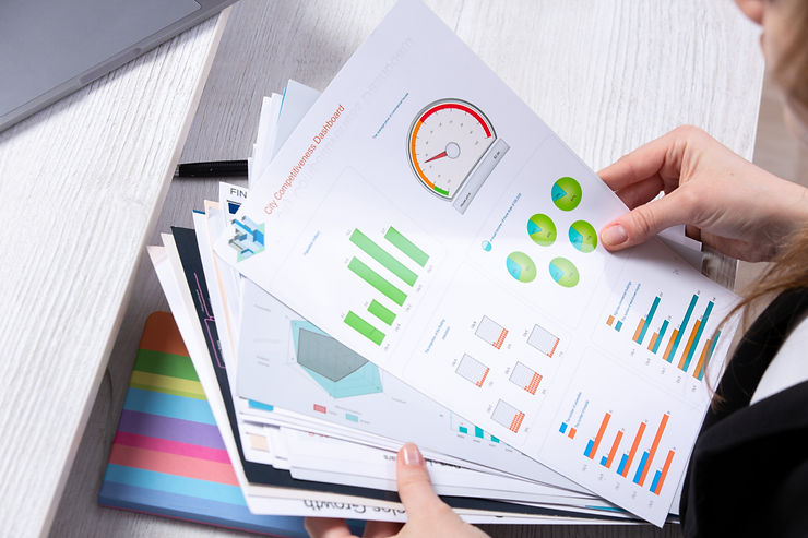 woman flips through a stacks of graphs and infographics in her hands