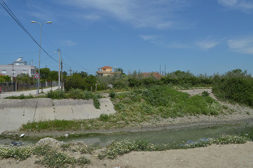 Pojan, road, houses, drainage channel, muddy banks