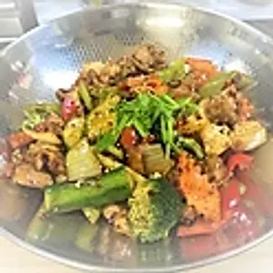 T1. Gebratene Hähnchenschenkeln (ohne Knochen) mit Kartoffel und Gemüse nach Szenchuan Art serviert in eine Pfanne. Dry fried chicken thighs, potatoes and vegetables in a Sichuan style serviced in a p