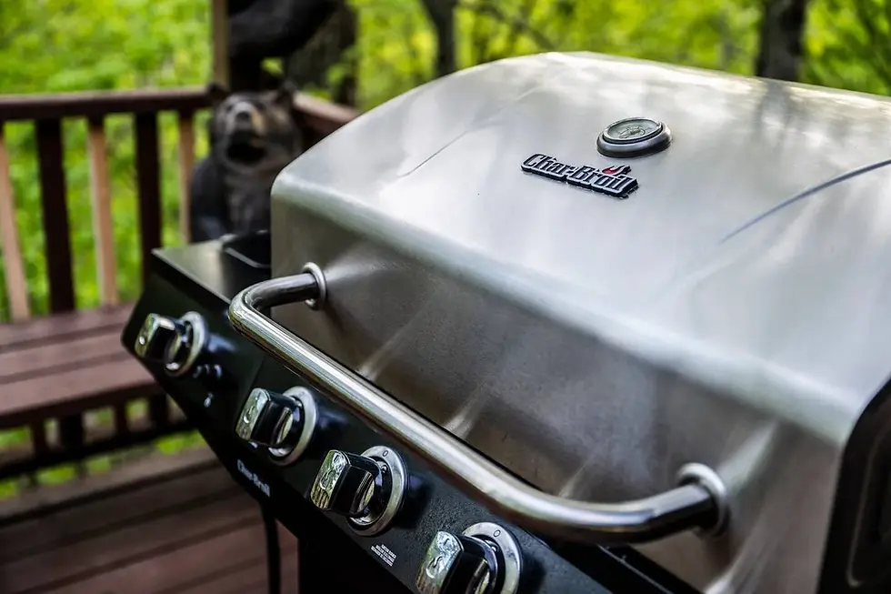 Stainless steel gas grill on wooden deck with forest view, outdoor entertaining amenity in Banner Elk