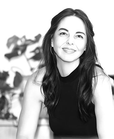 Black and white image of woman smiling with long dark hair and black top