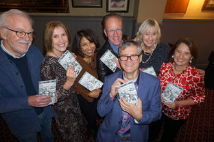 a group of writers holding their new book at a book launch