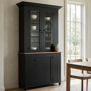 Tall early American cupboard in Historic Charcoal with cherry top, featuring glass upper doors, paneled lower doors, and a balanced vertical two-part form