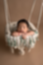 Newborn boy asleep in boho swing in Eugene, Oregon photography studio