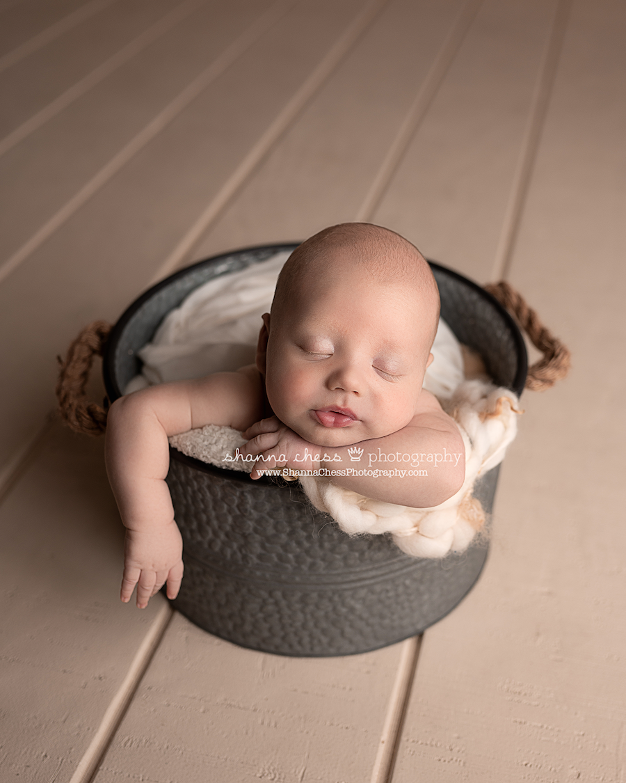 Infant boy asleep in bucket in Eugene Oregon photo studio