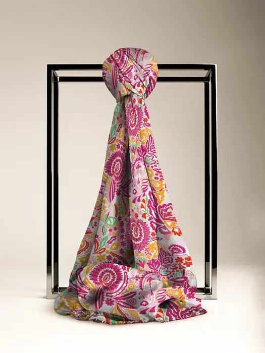 Colorful scarf with pink, yellow, and green floral and paisley designs knotted on a display, reflecting Vrijesh Natural's intricate pattern work.