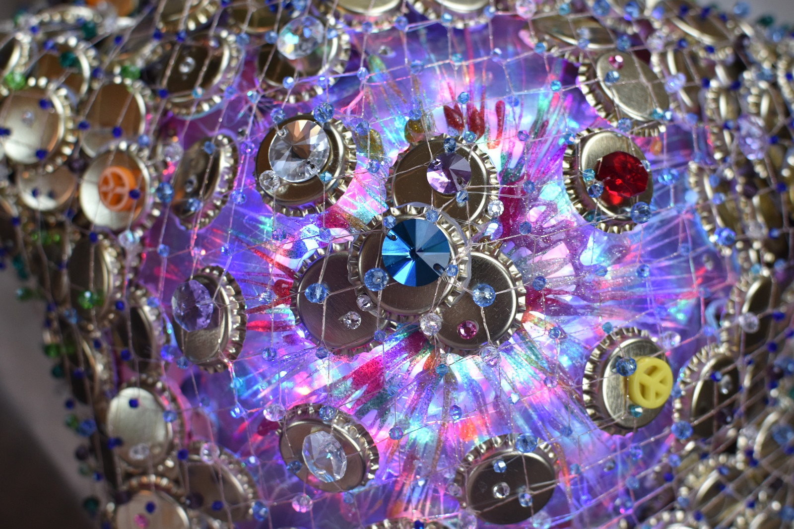 Close up of one of the star props - made from bottletops, plastic bottles and fishnets with a light inside, beaded with Swarovski crystals.