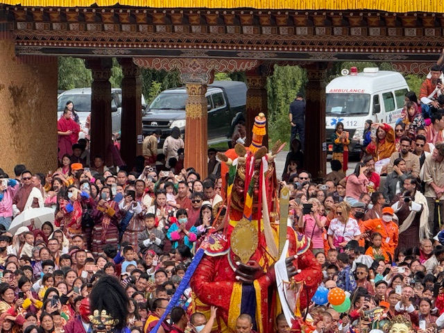 Masked dancers whirl in vibrant brocade, performing sacred cham rituals to bless onlookers.