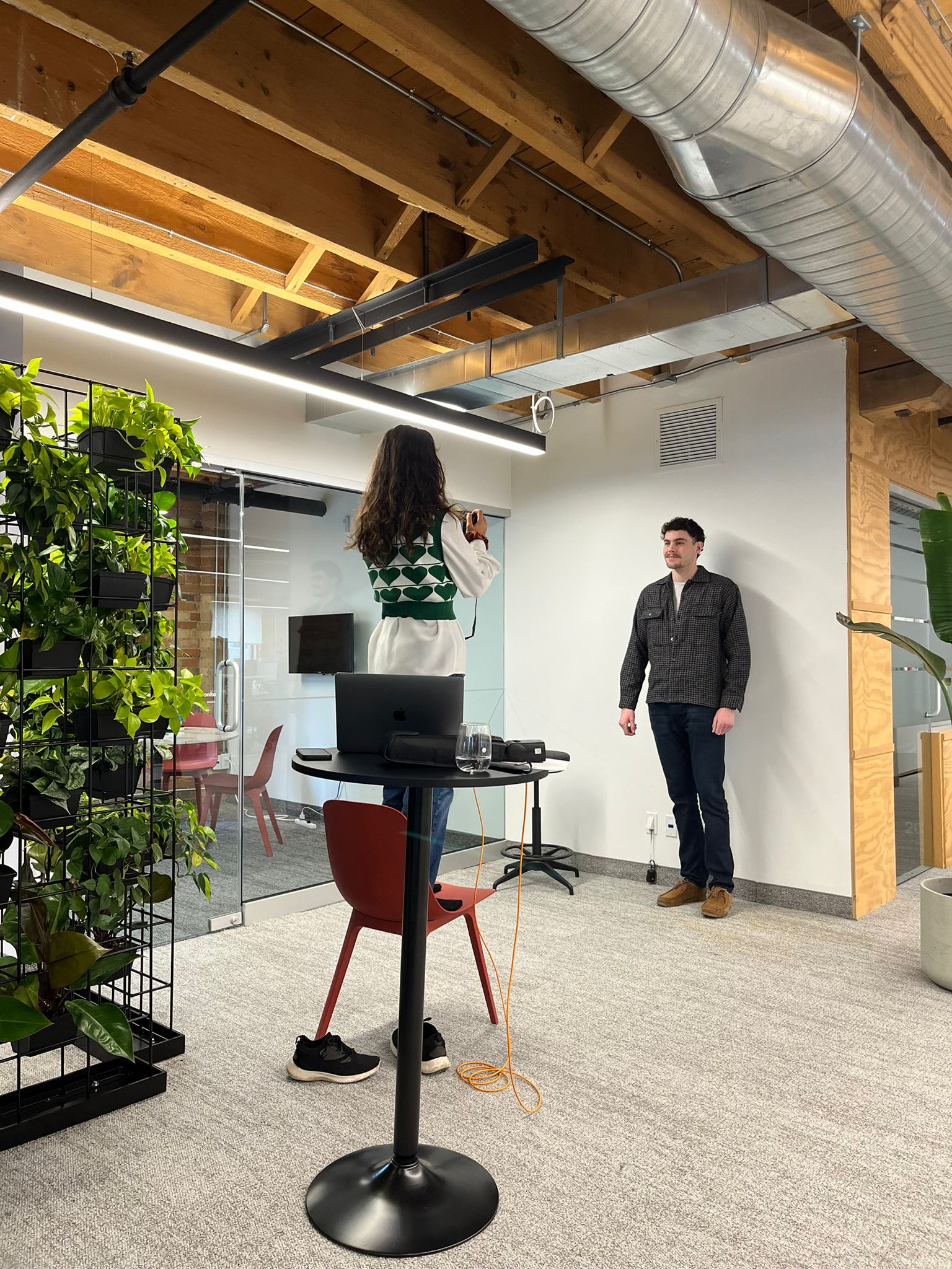 The brand photographer taking photos at a corporate office, showing the process of creating authentic brand photography