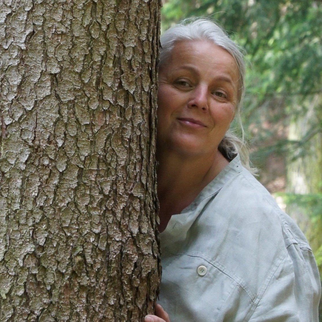 Frau lehnt an Baum