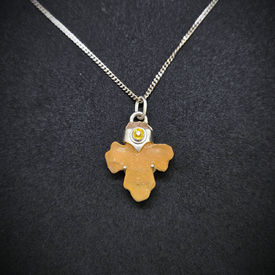 Ethiopian carved alabaster cross pendant with a yellow sapphire accent stone