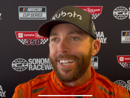 Ross Chastain smiling in his orange Kubota fire suit and black hat during media availability at Sonoma Raceway ahead of the 2025 Toyota/ Save Mart 350