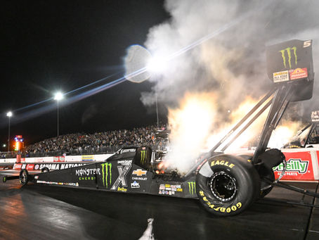 Brittany Force's Monster Energy/Top Fuel dragster launches off the starting line at night during her record-setting343.16-mph run at the 2025 NHRA Sonoma Nationals, with flames visible from the headers.