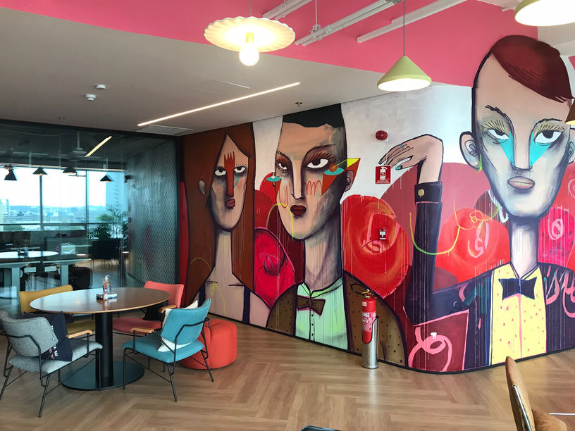 pintura artistica com cores vibrantes dentro de um escritorio com moveis de design