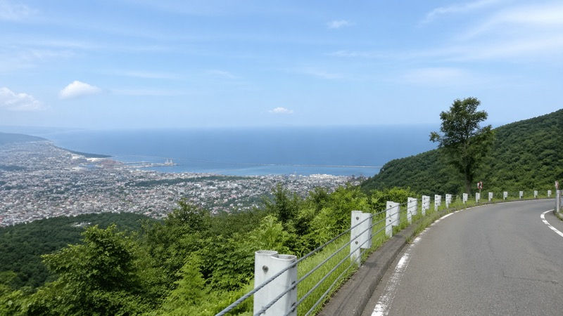 天狗山麓の道路沿いから見下ろす小樽市街と海の眺め