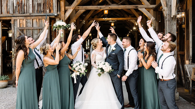 Mariés et leur cortège se réjouissent. MARIAGE devant un bâtiment en bois.