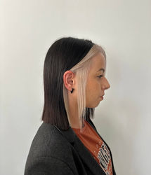 Femme de profil, cheveux courts bicolores noir et blond platine.