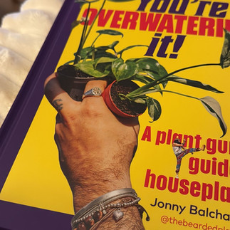 Happy customer showing their copy of You’re Overwatering It! houseplant guide by The Bearded Plantaholic.