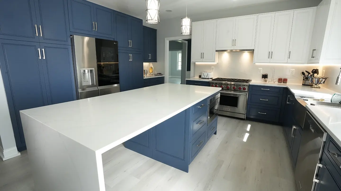 Modern kitchen with blue cabinets and white countertops.