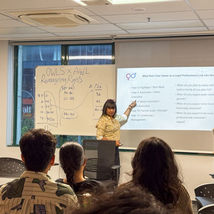 Woman presenting to students with a projector screen