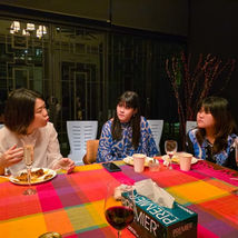 Three women conversing at a colorful dinner table