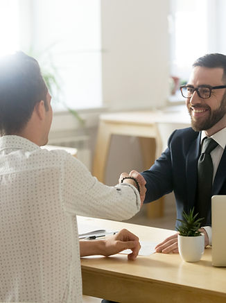 Smiling lawyer, realtor or financial advisor handshaking young couple thanking for advice,