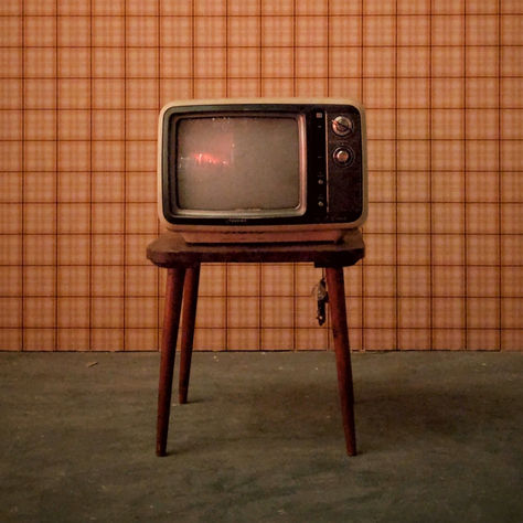 An old television on a small table, switched off