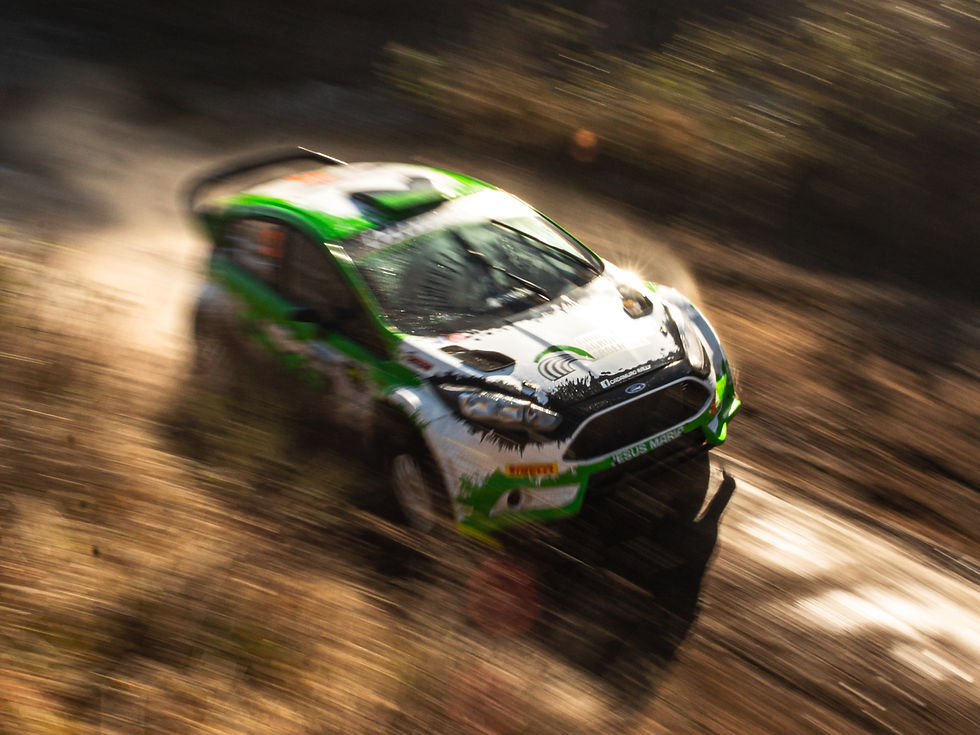 A rally car speedily drifting through a tricky corner