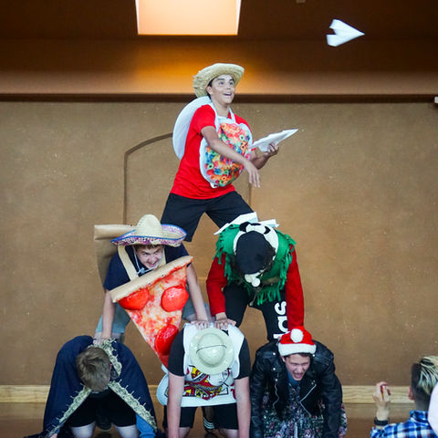 Human pyramid of teenagers in silly costumes
