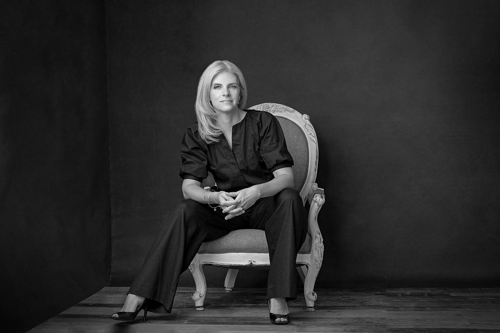 Monica de Wit founder and CEO of HUGO & Company sitting on a chair, black background