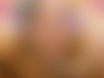 An older woman wearing large earrings, pearls, and fur shawl, smiling